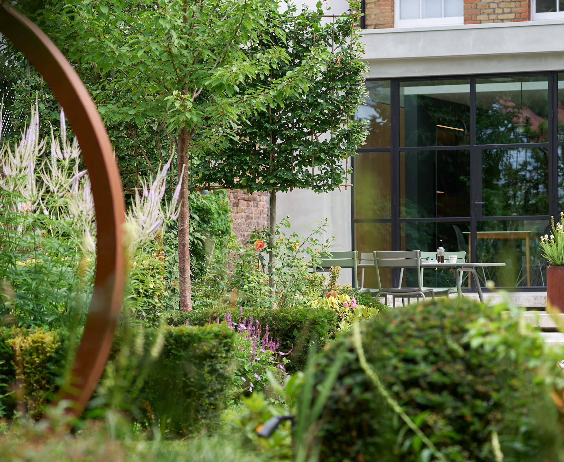 An intimate view taken on a long lens across the length of the garden, revealing the balancing forms and textures of the planting.