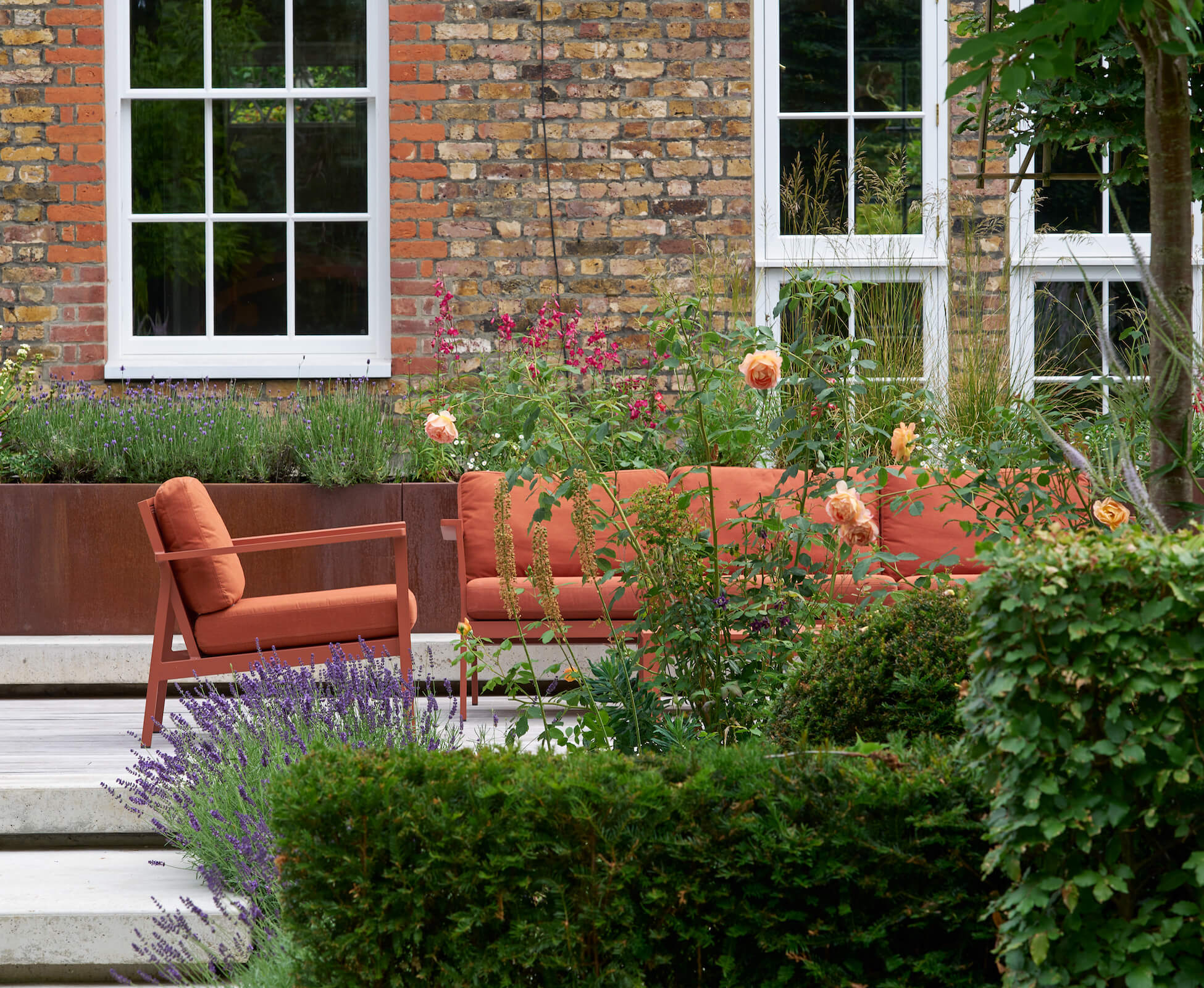 Bringing the planting closer to the house allows for a more sheltered, intimate seating area. The corten planters wrap around hidden light wells into the basement, and conceal the roof lining.