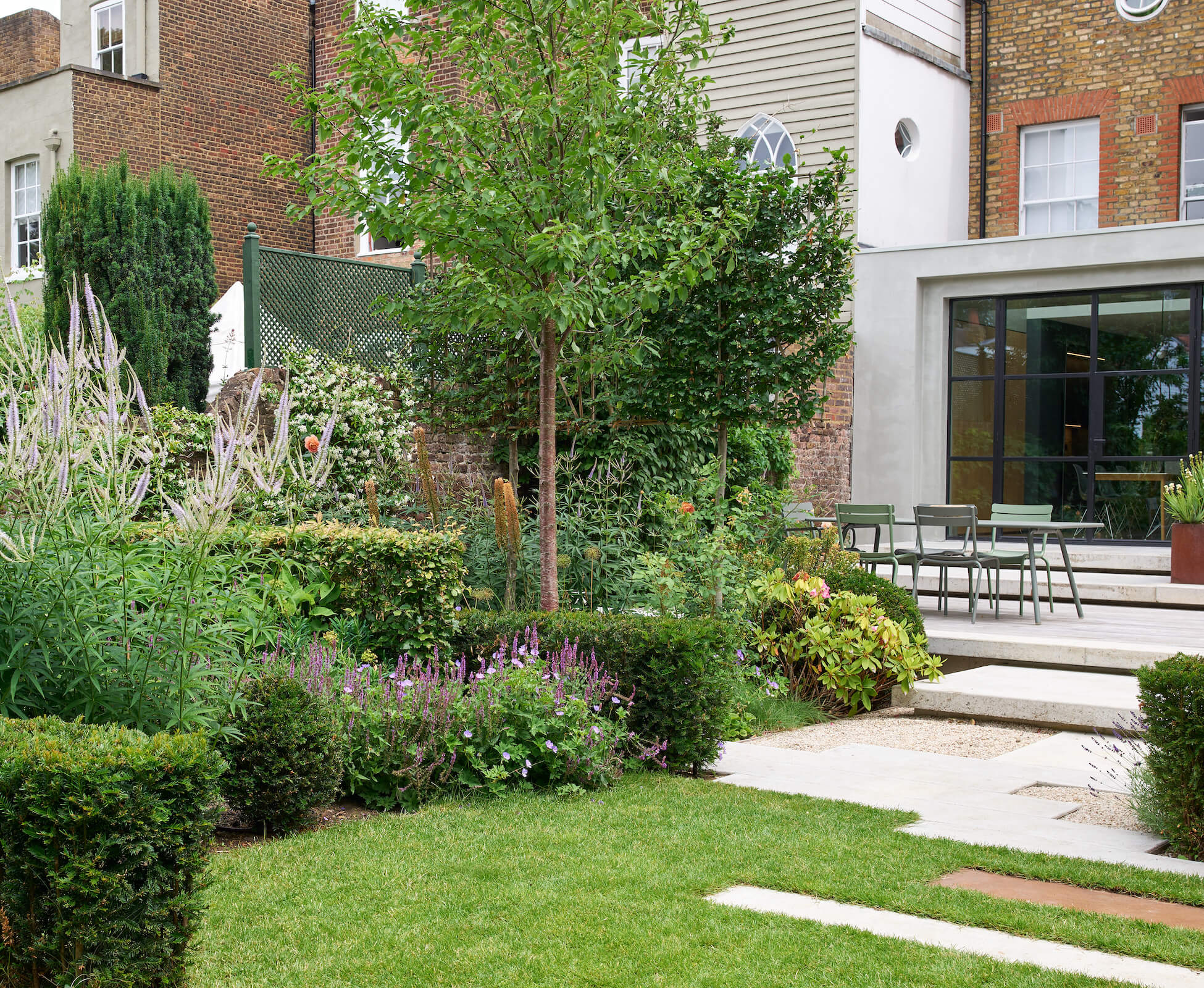 The trees provide some screening from the immediate neighbours windows, The floating concrete steps tie in architecturally with the micro-cement finish to the house extension.