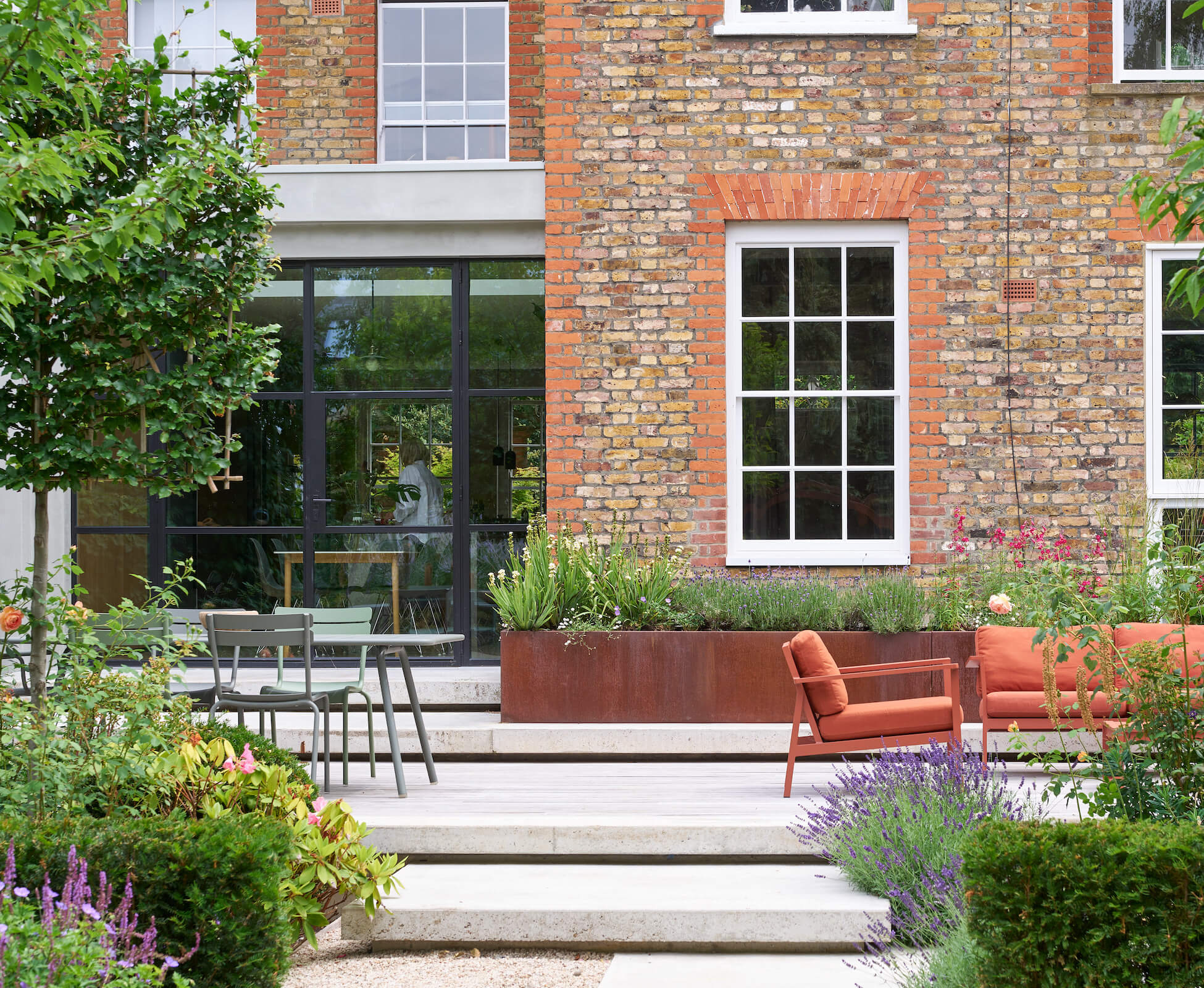 The shadow gaps designed into the concrete landings and steps, create a lightweight feel that make them appear to be floating above their foundation. The textured patina of the corten planter ties in with the old brickwork on the house.