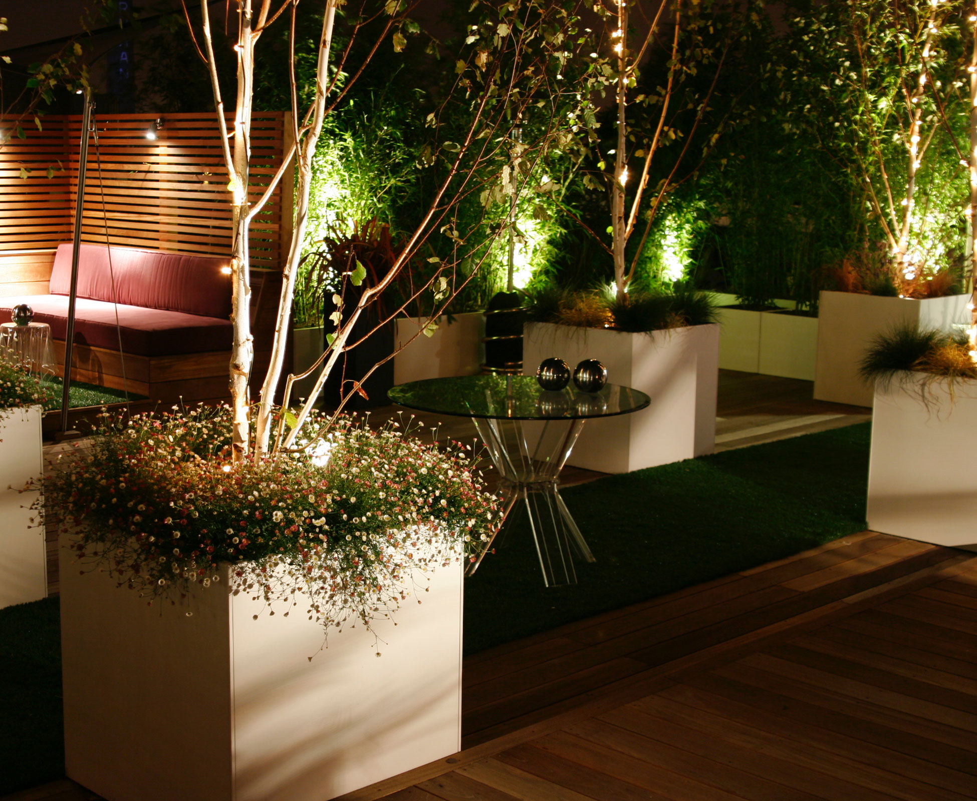 At night, the multistem birch trees are unlighted with LED spots in their planters creating a soft warm light to enjoy.
