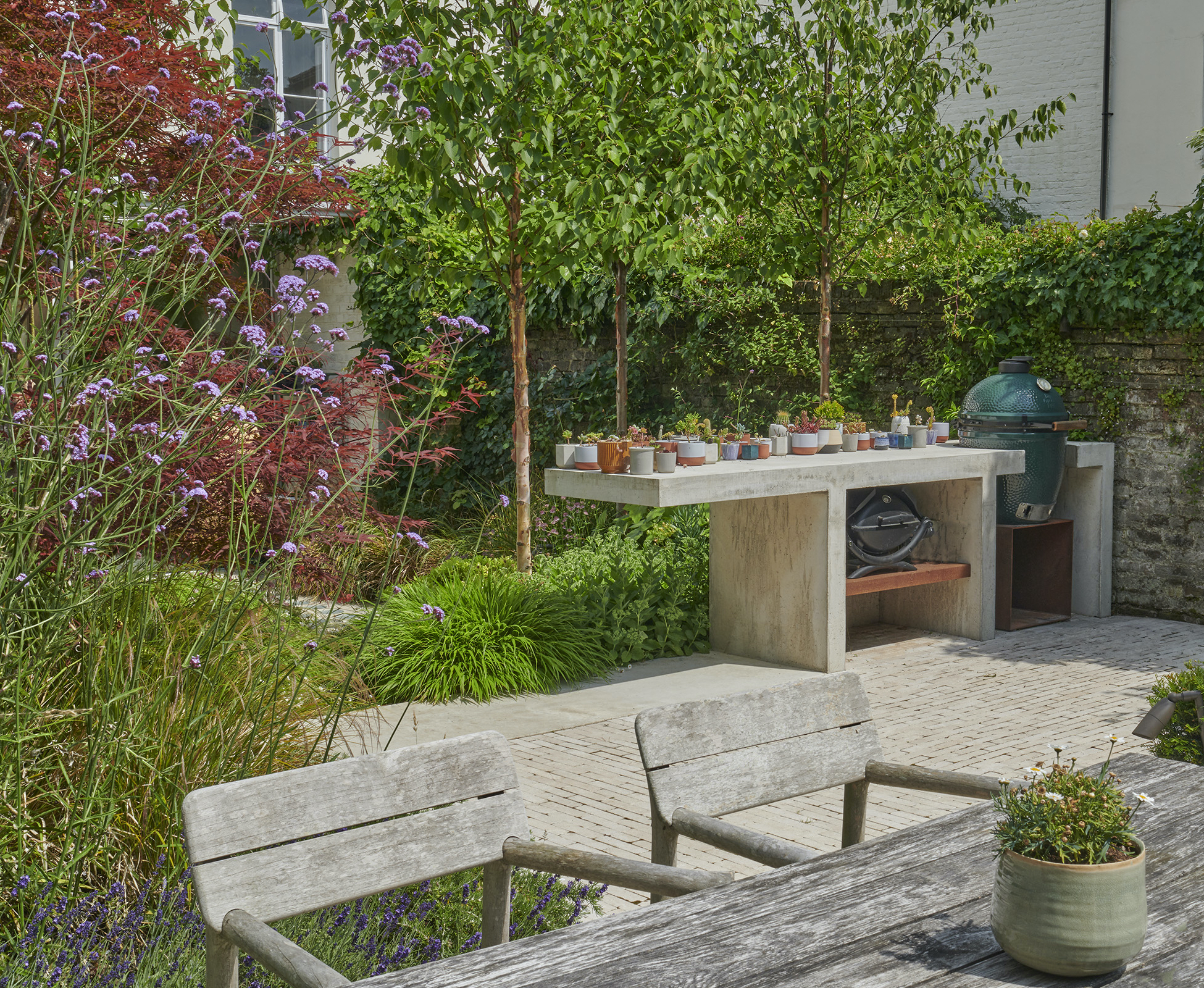 Close-up of the timber table and chairs dining set, with the elegant smooth concrete kitchen worktop visible in the background.