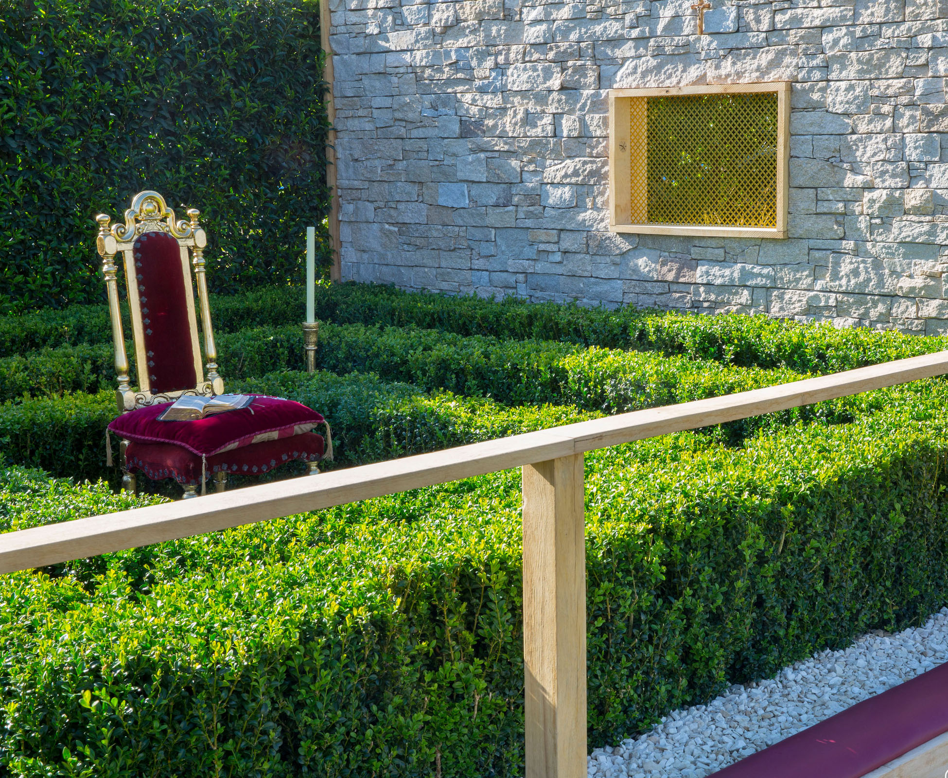 This conceptual garden designed on the theme of the seven deadly sins, expresses Greed at Hampton Court Palace Show Garden. An oak timber framed window is built into the stone clad feature wall, creating separation between the two spaces.