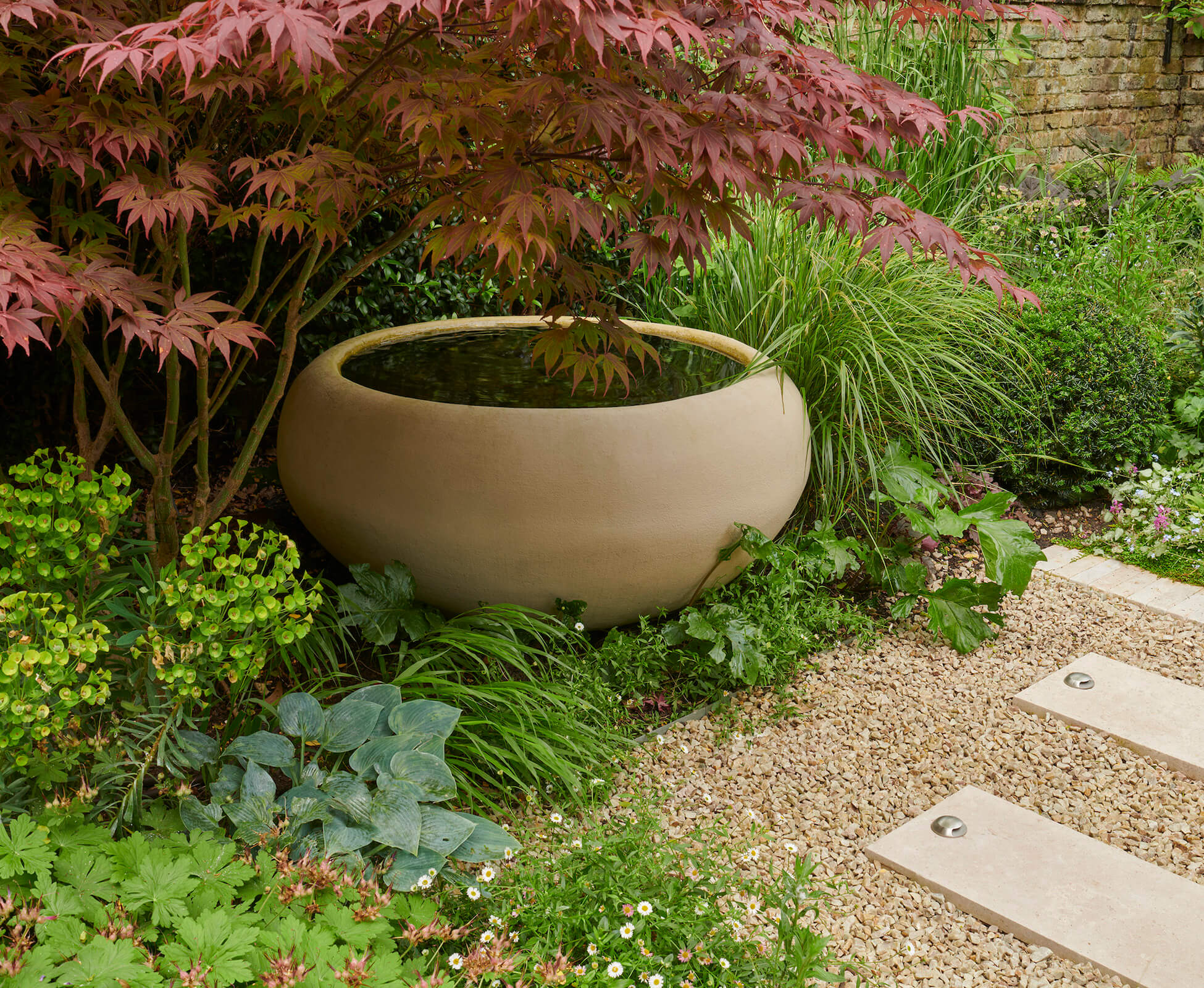 The Urbis poppy bowl provides a subtle focal point and water feature within this Highbury garden, beautifully offset by a Japanese acer. 