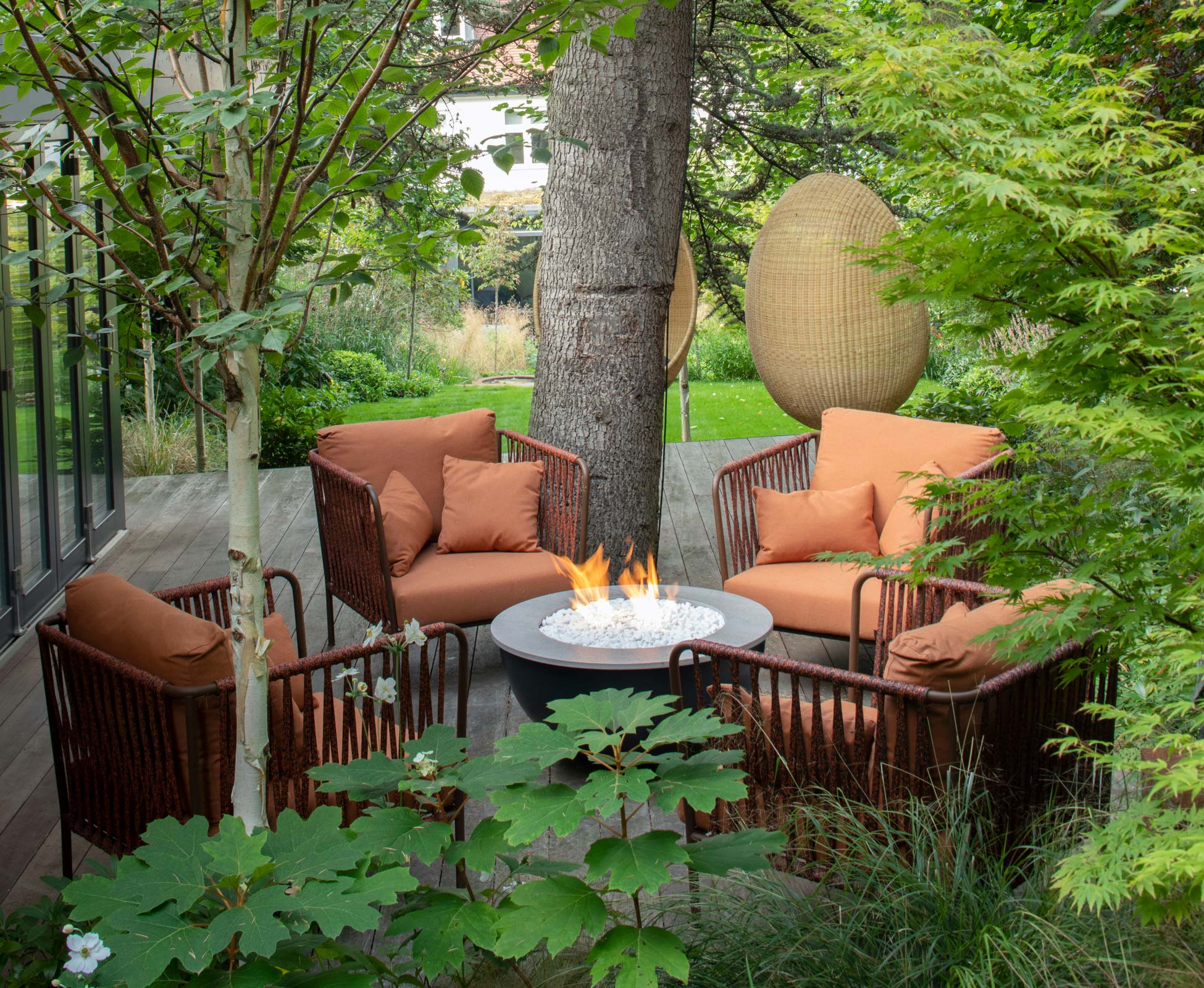 A cozy seating area on the garden studio decking enveloped in lush green; it’s our clients favourite corner to sit and enjoy the garden view.