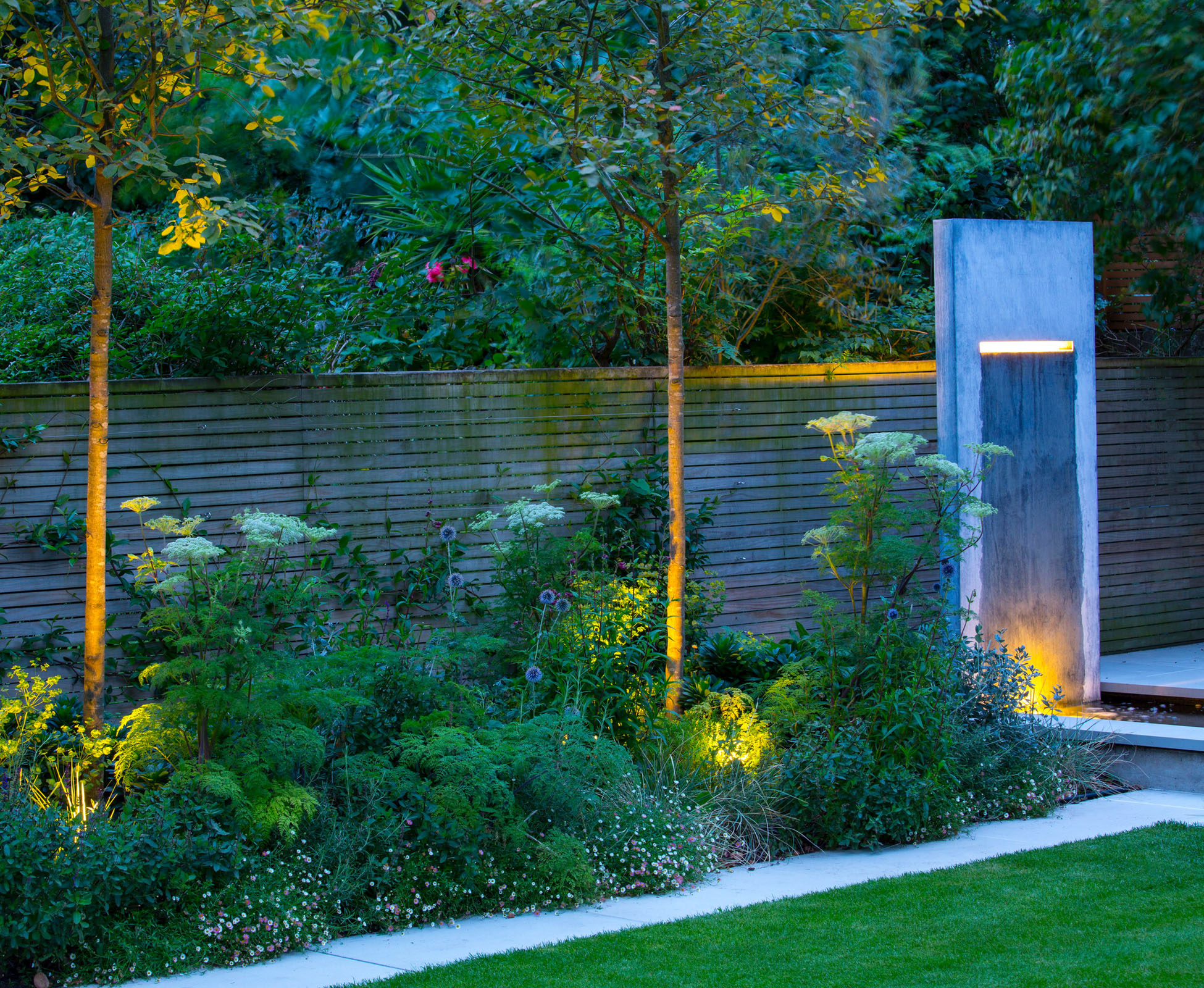 At dusk, this Islington garden is enchanting when the trees are up lit with a warm white LED. The foliage of the cow parsley appears even more delicate.