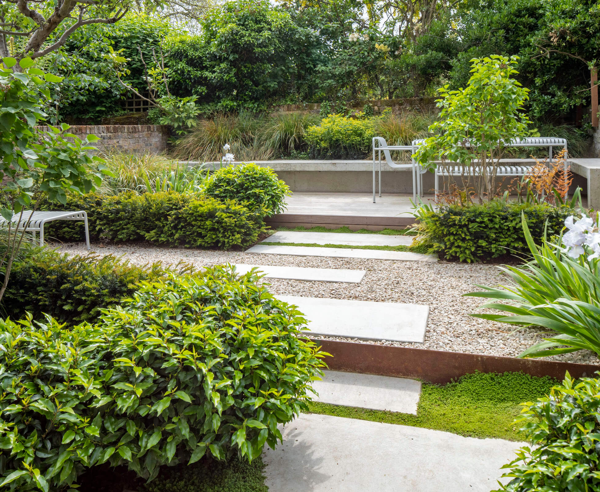 We used quite a subtle palette of materials and planting in this garden, to emphasise the feeling of width and space. Poured concrete stepping stones and Quartzite gravel are the key materials, with hardwood deck and edging in Corten steel.