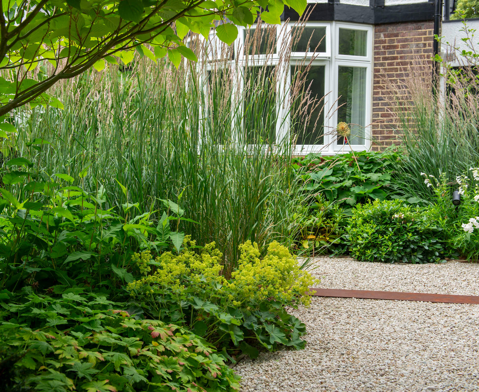 Off street parking in this Mill Hill front garden, is carefully balanced with planting and textural gravel to ensure the cars don’t dominate the frontage.