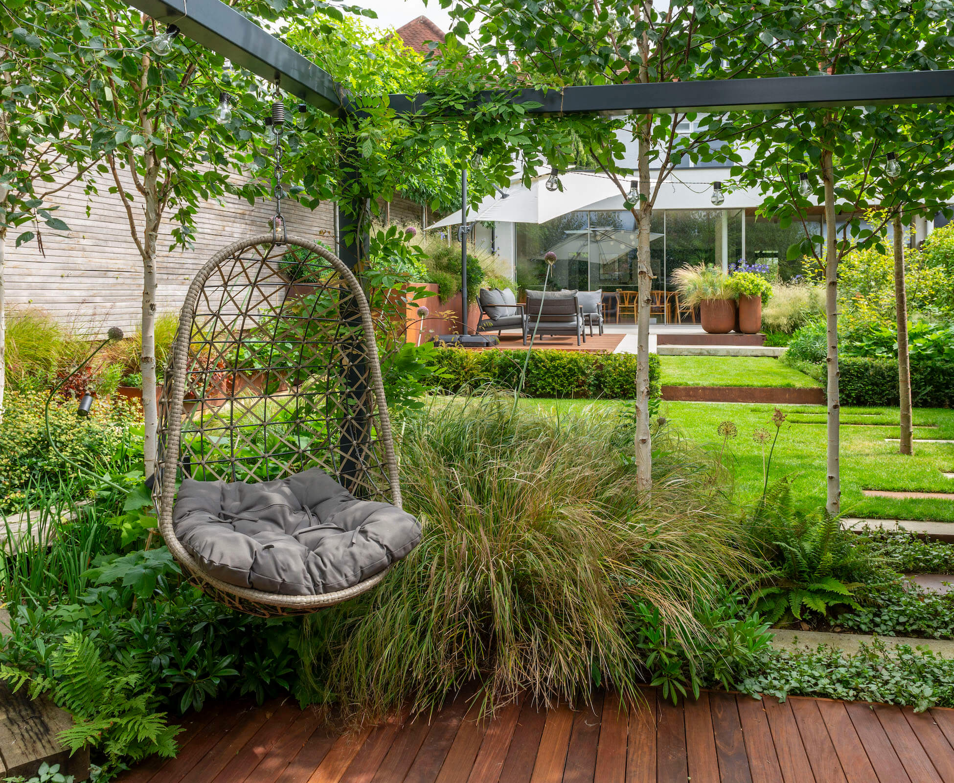 A seating spot under a pergola allows for interchangeable hanging pod chairs or play equipment for the clients children, whilst providing respite from the sun drenched patio.