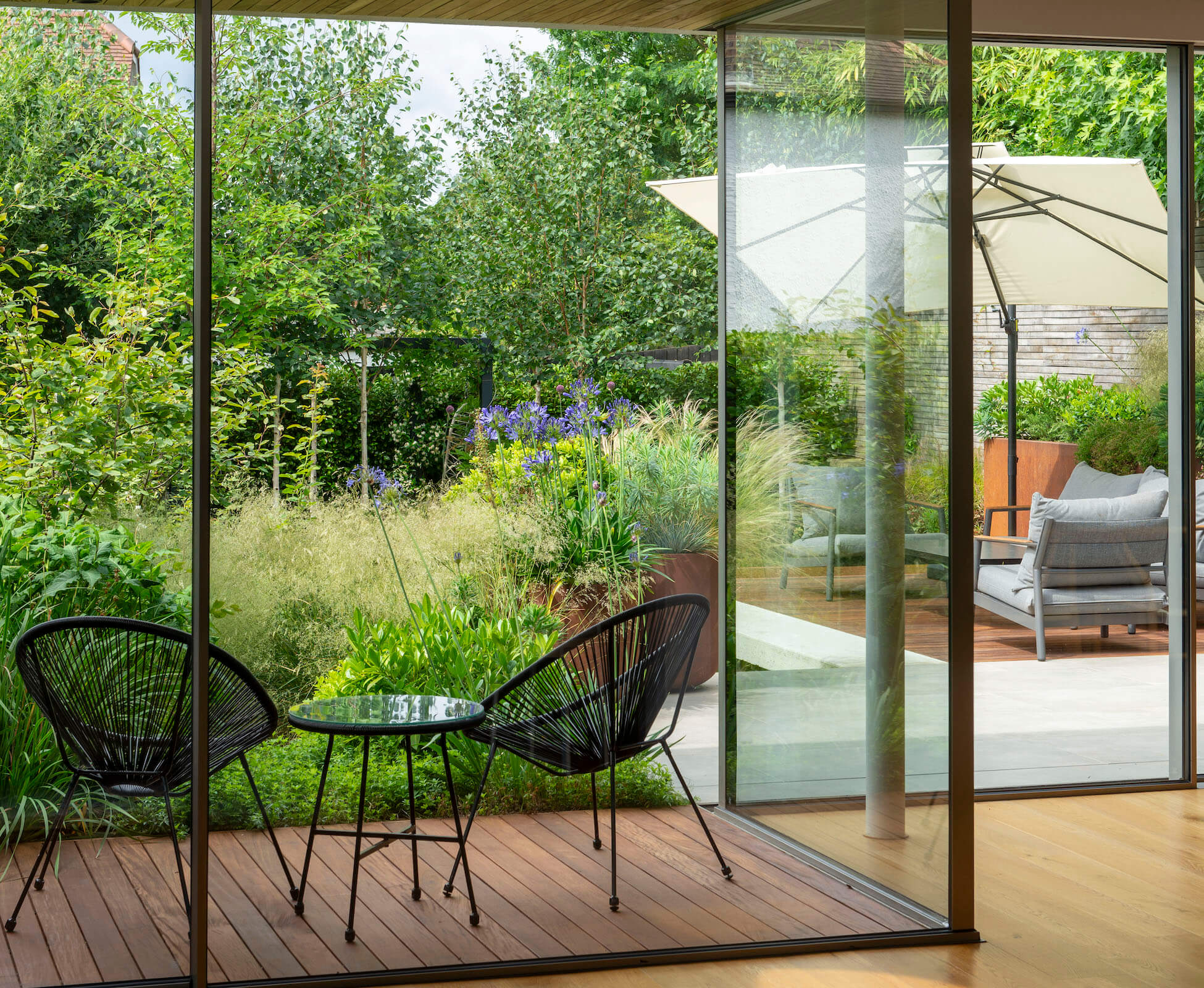 The new sliding glass doors allow for an inviting view of the garden, with an intimate covered seating spot, that allows the planing to embrace the house.