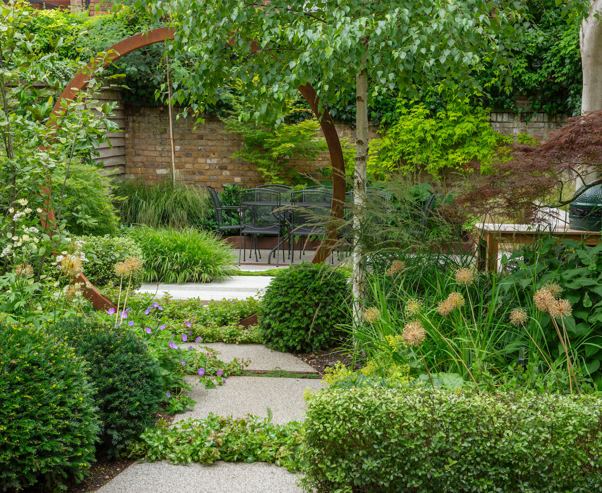 The Corten moongate provides a subtle focal view to lead you through the garden and down towards the rear seating area. The planting is a carefully balanced tapestry of textures, shapes and shades of green to provide interest throughout the seasons.