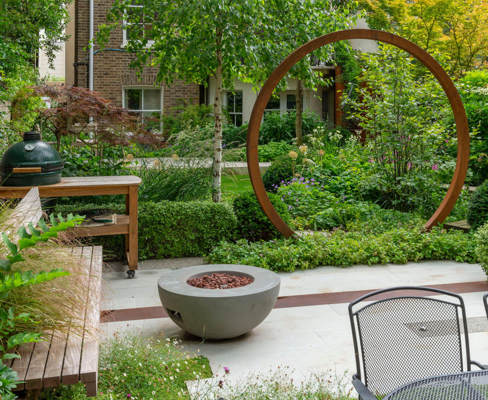 A built in hardwood bench under the existing Sycamore tree, provides a good place to sit with a gas firebowl for chilly evenings. The big green egg can be wheeled out for entertaining.