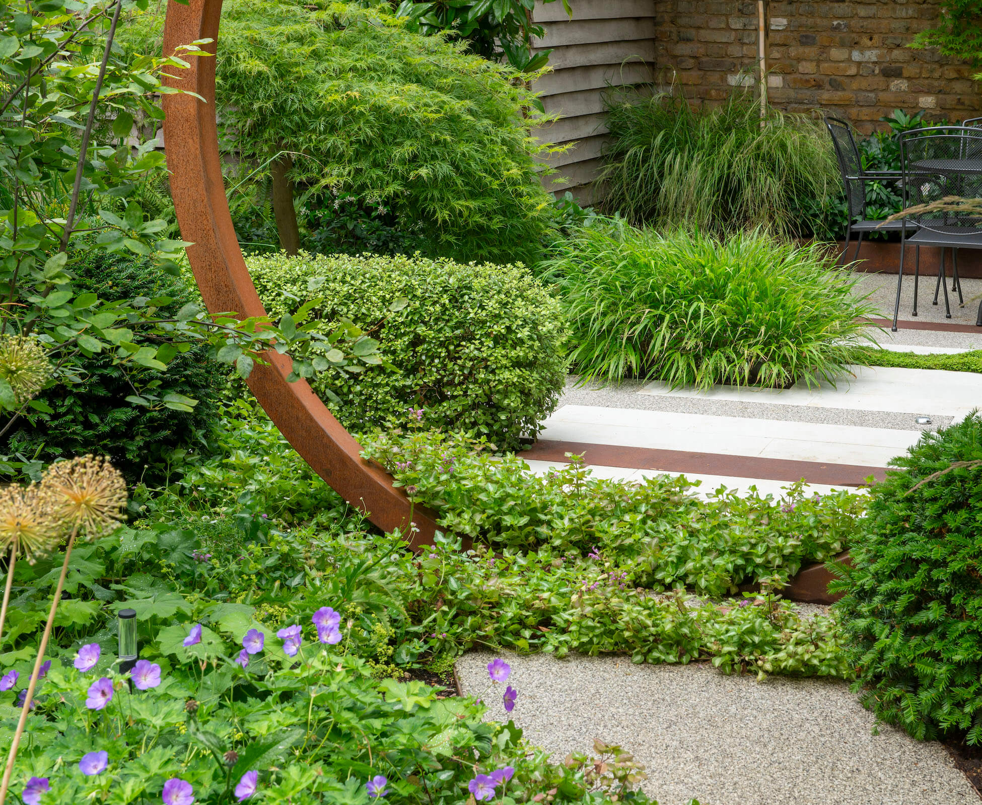 Lamium is carefully placed in horizontal bands to break up the paving and resin bound path, and emphasize the width of the garden.