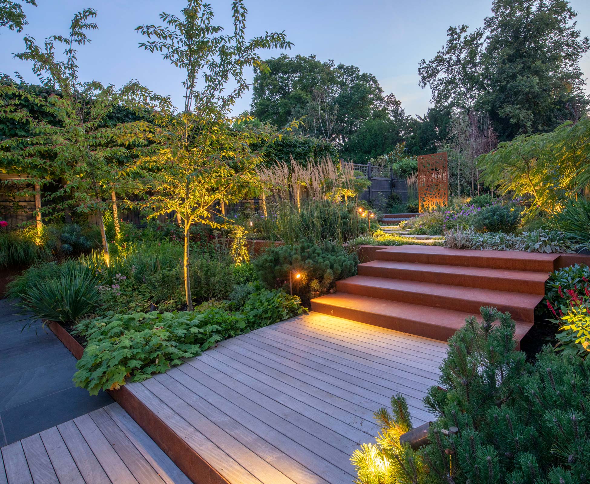 When night comes and the lights are turned on the focal corten steel panel becomes a strong feature from the patio.
