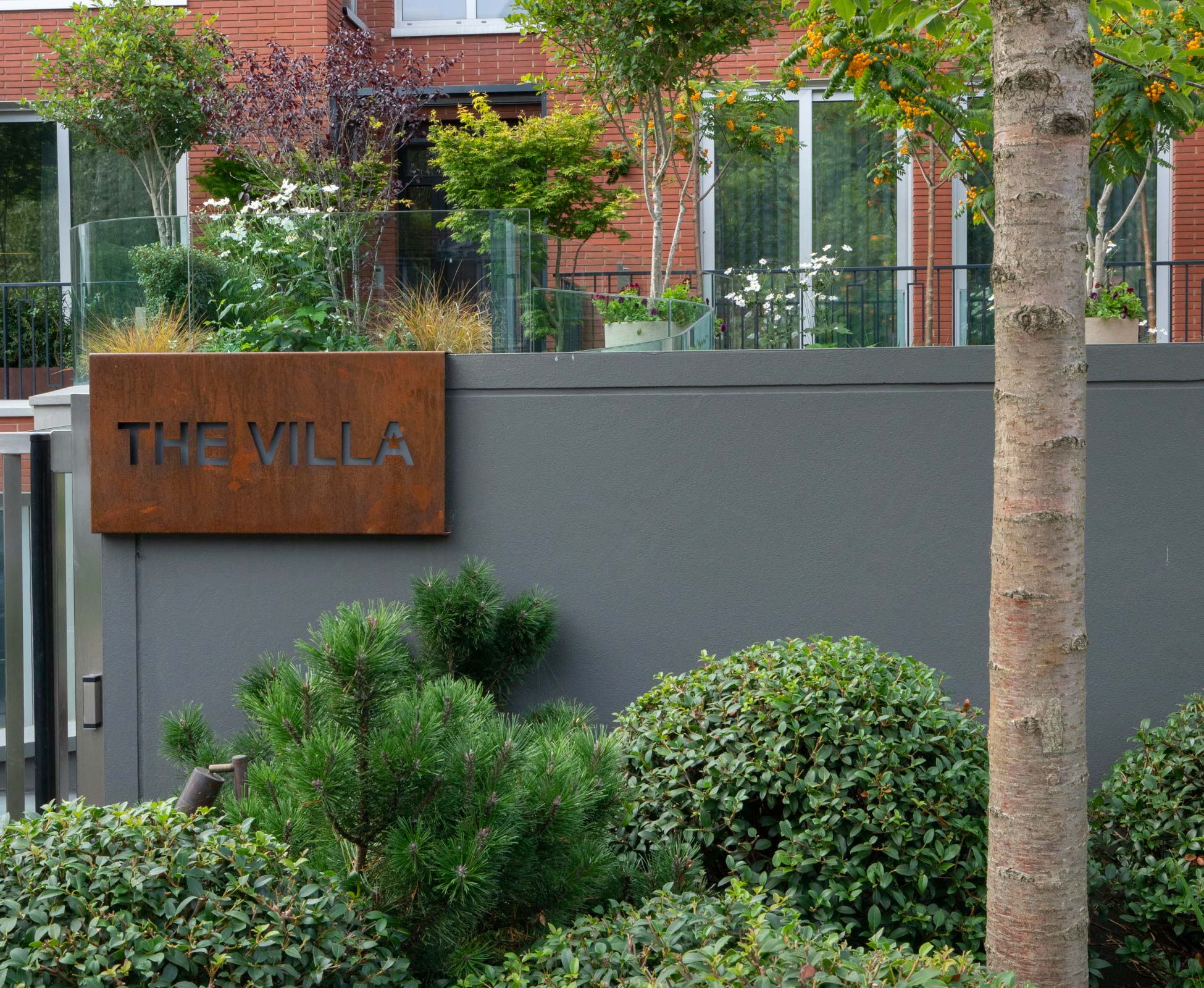 A bespoke corten steel sign at the front entrance to tie in all the corten steel details at The Villa.
