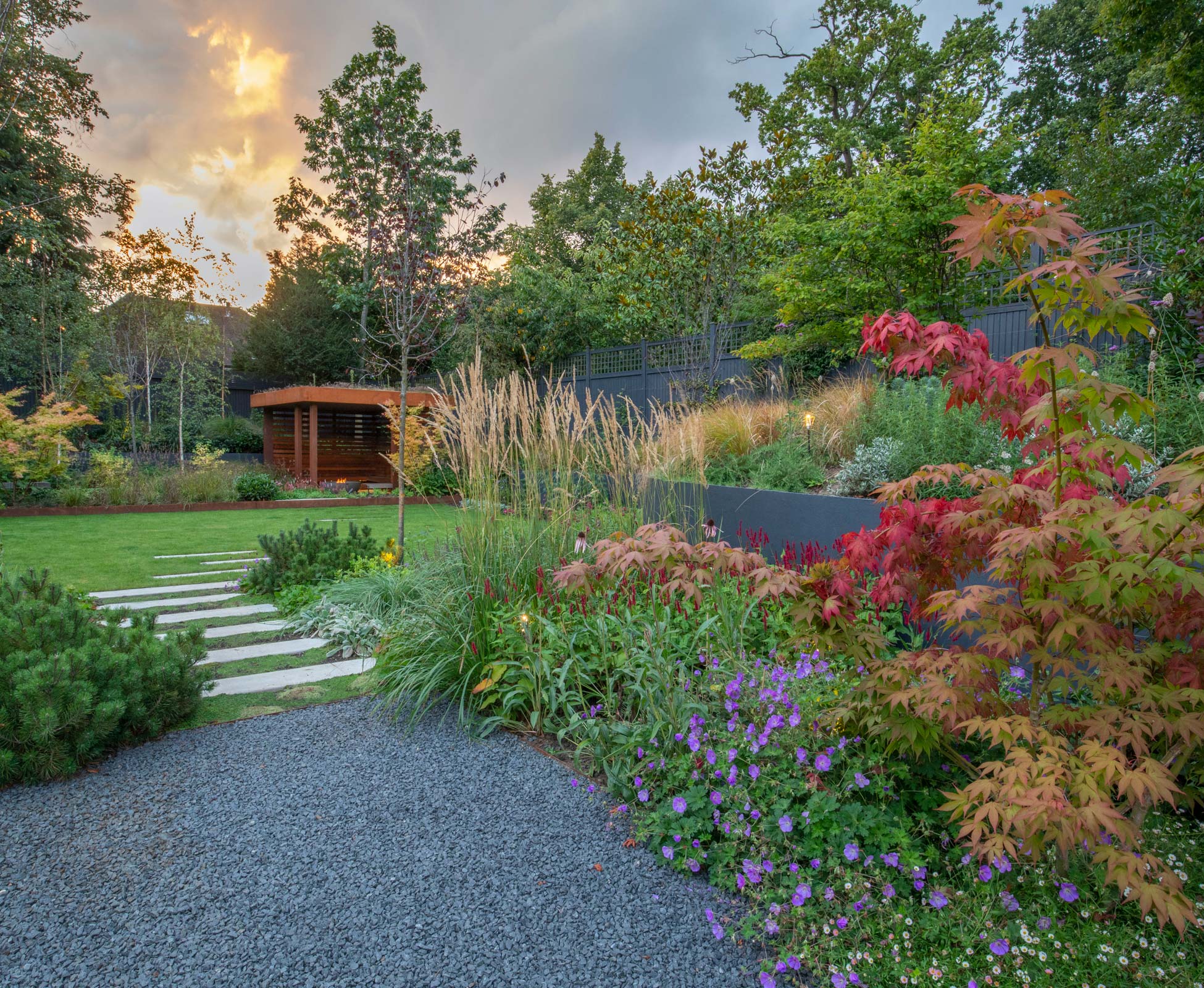 A staggered path through the lawn and planting leads to the hidden ‘Den’; it’s the perfect cozy corner to seat and enjoy the view of the garden while warming up in front of the fire pit.