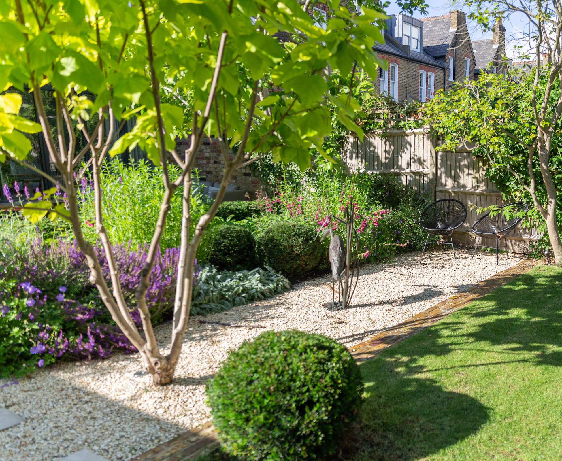 The multi-stem Indian Bean tree is planted in gravel to ensure it remains free draining and acts as a key focal point in this intimate seating spot.