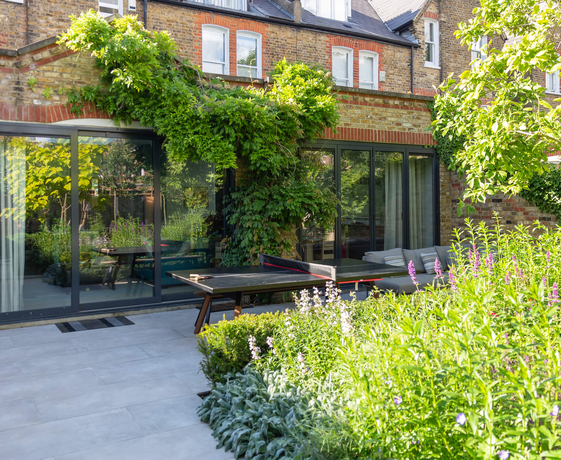 The view back to the rear kitchen extension shows the full width of the patio, which accommodates a decent size entertaining space. We managed to retain the clients climbing wisteria during works.