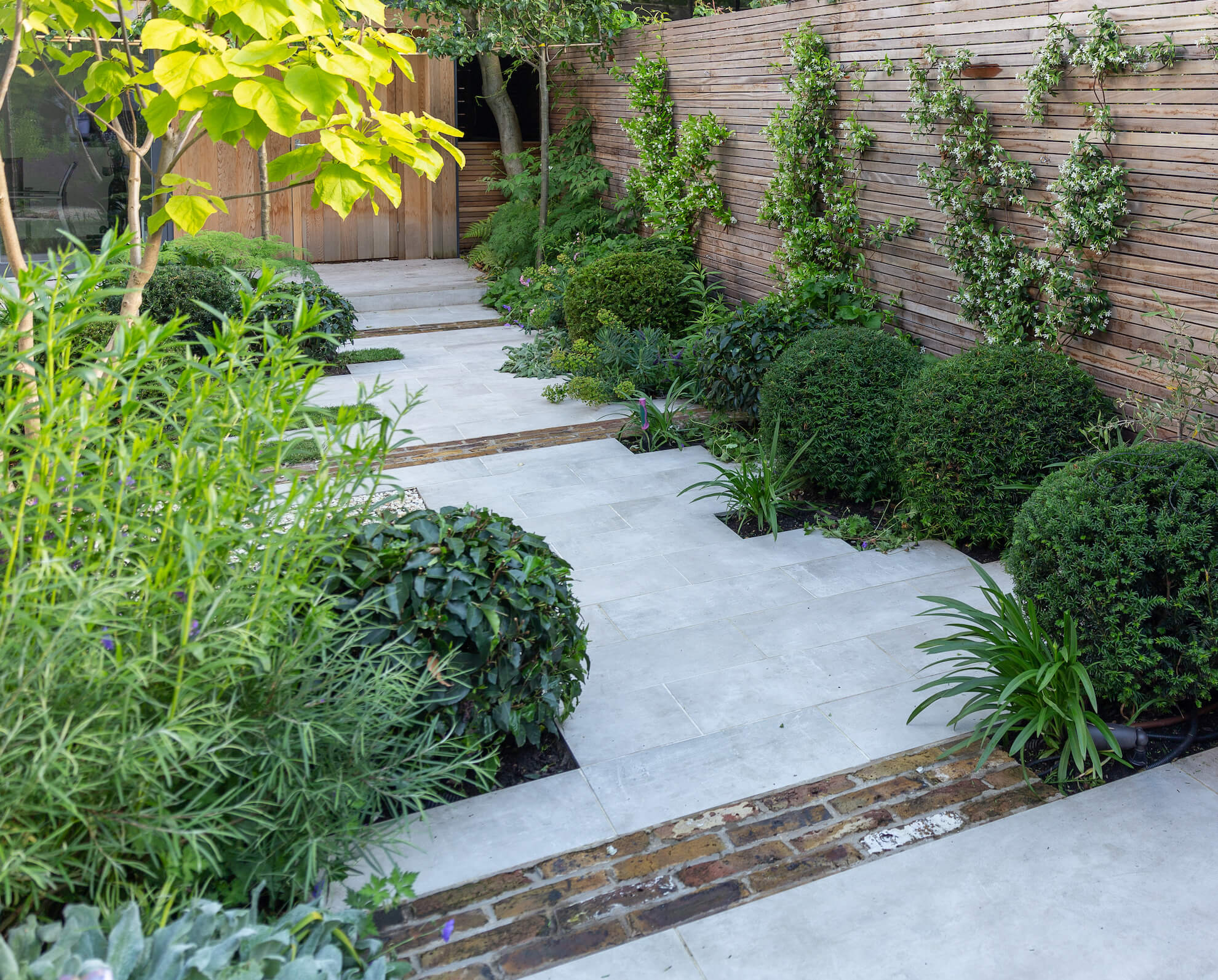 Domes of Taxus baccata and Prunus Lusitanica are off set with Euphorbia, Agapathus, Salix, Salvia and Penstemon.