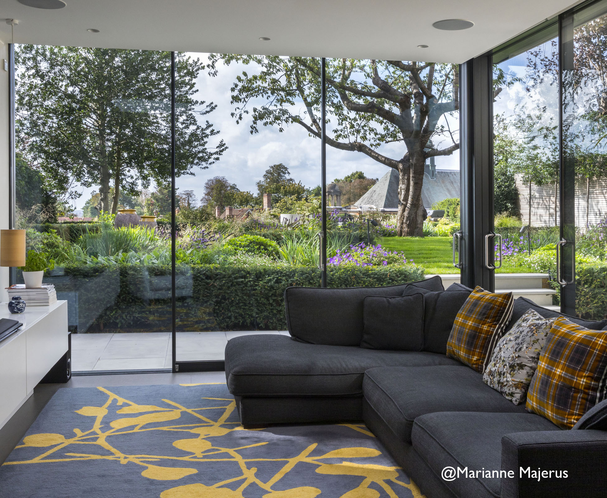 Garden view from the indoor lounge area, the yellow details of the interiors are echoed in the garden with the yellow glazed trim of the clay pots. 