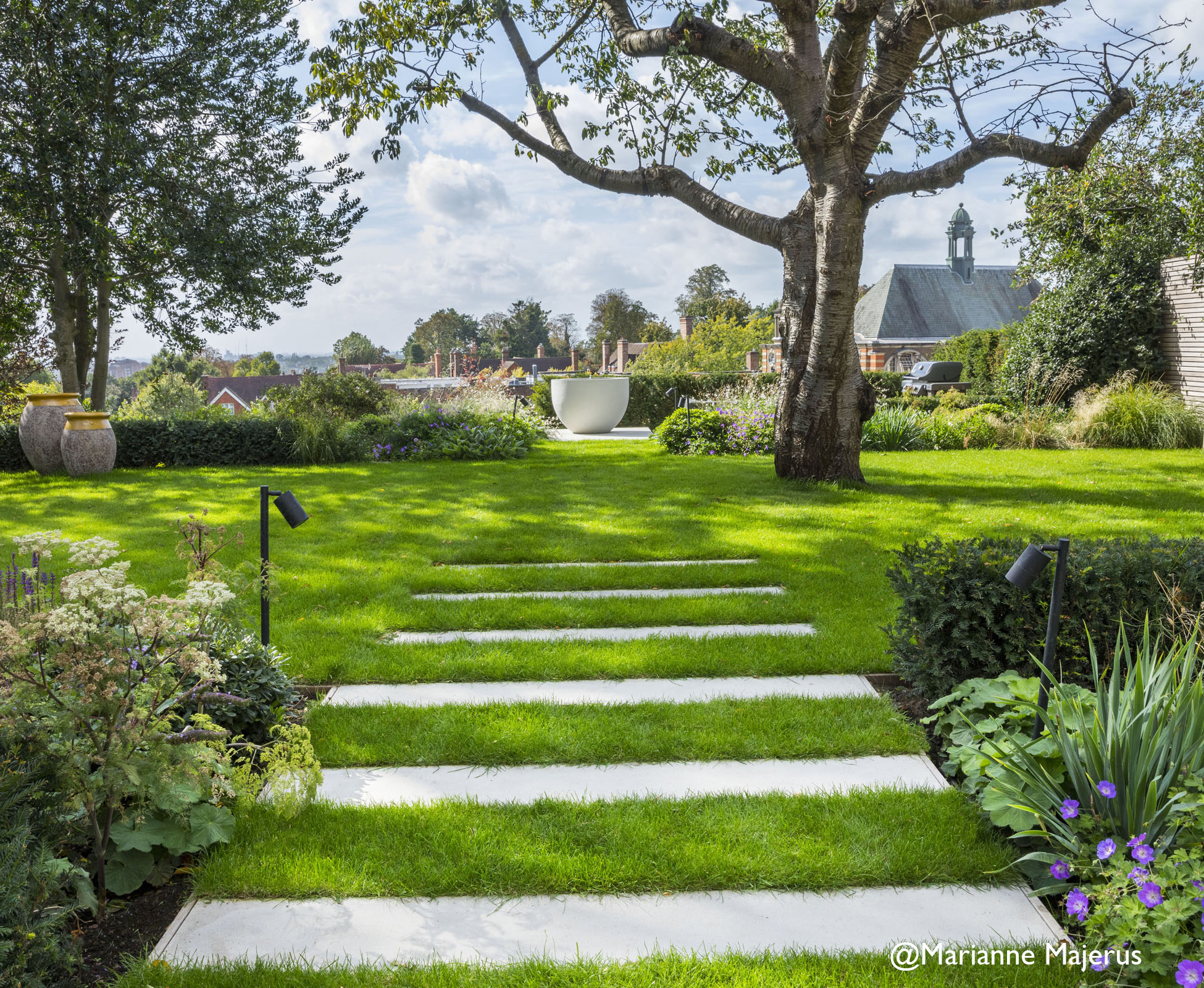 A decent size lawn hugs the central ornamental cherry tree, whilst 3 metre deep, herbaceous borders, span the full width of the garden, creating a diaphanous backdrop above which the skyline remains visible.